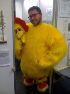 Man grinning in yellow chicken suit